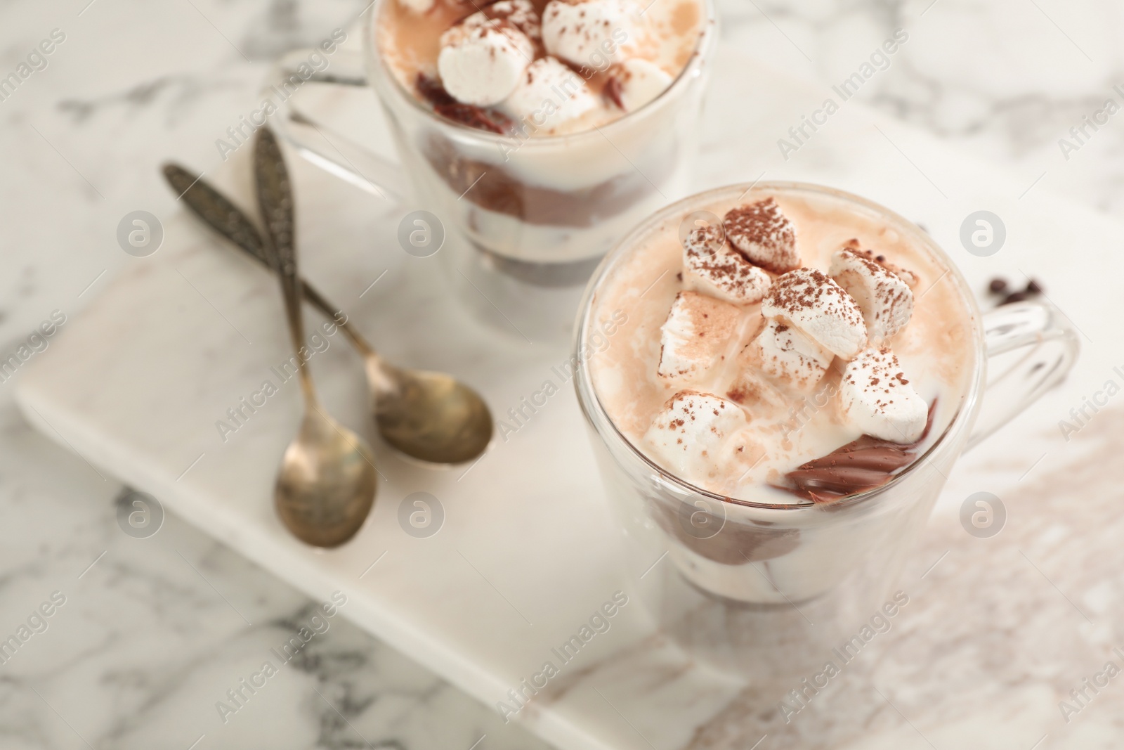 Photo of Cup of chocolate milk with marshmallows on marble table. Space for text