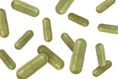 Vitamin. Many capsules falling on white background