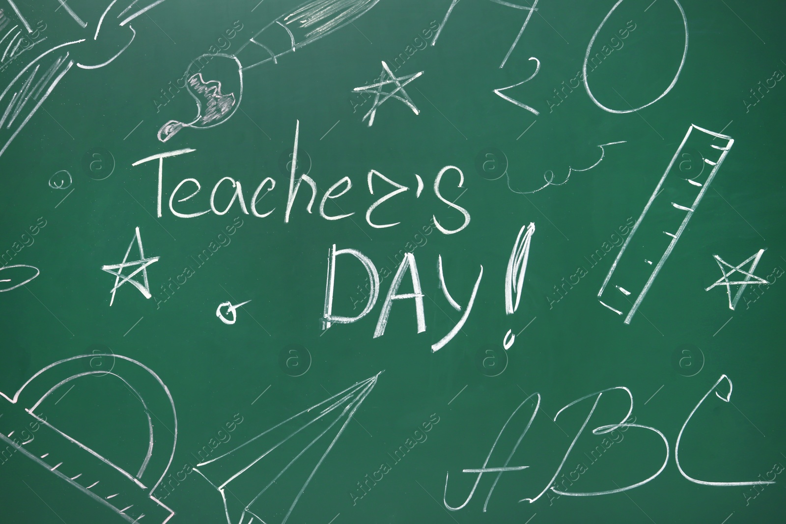 Photo of Green chalkboard with inscription TEACHER'S DAY and drawn stationery