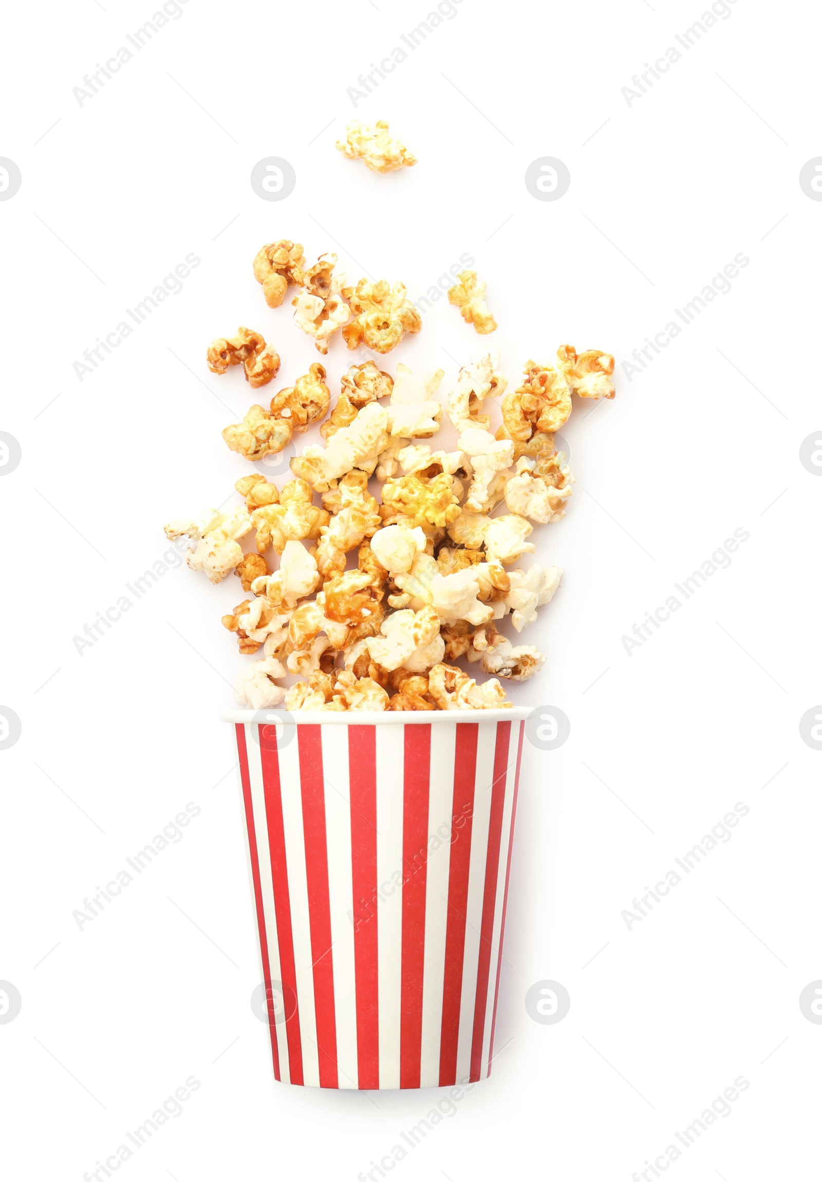 Photo of Overturned cup with delicious fresh popcorn on white background, top view