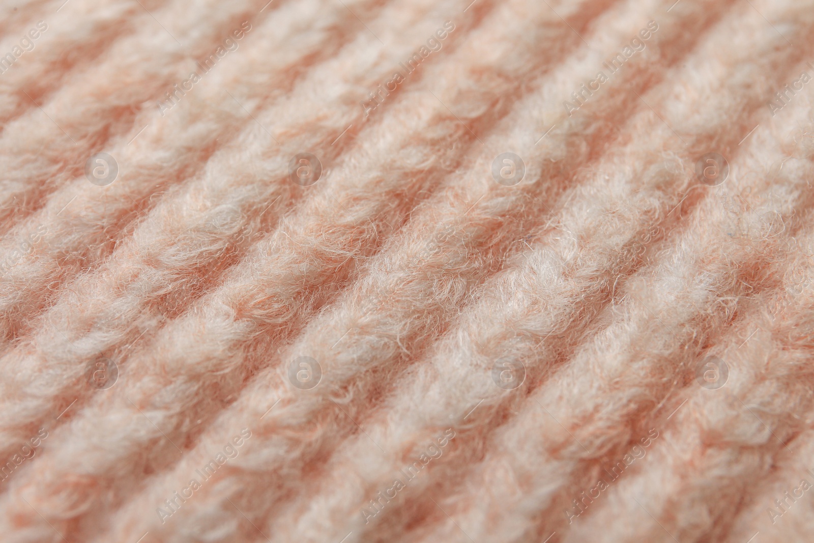 Photo of Beautiful pale pink knitted fabric as background, closeup