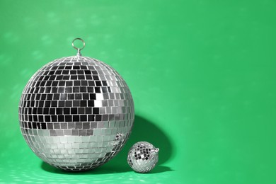 Photo of Shiny disco balls on green background. Space for text