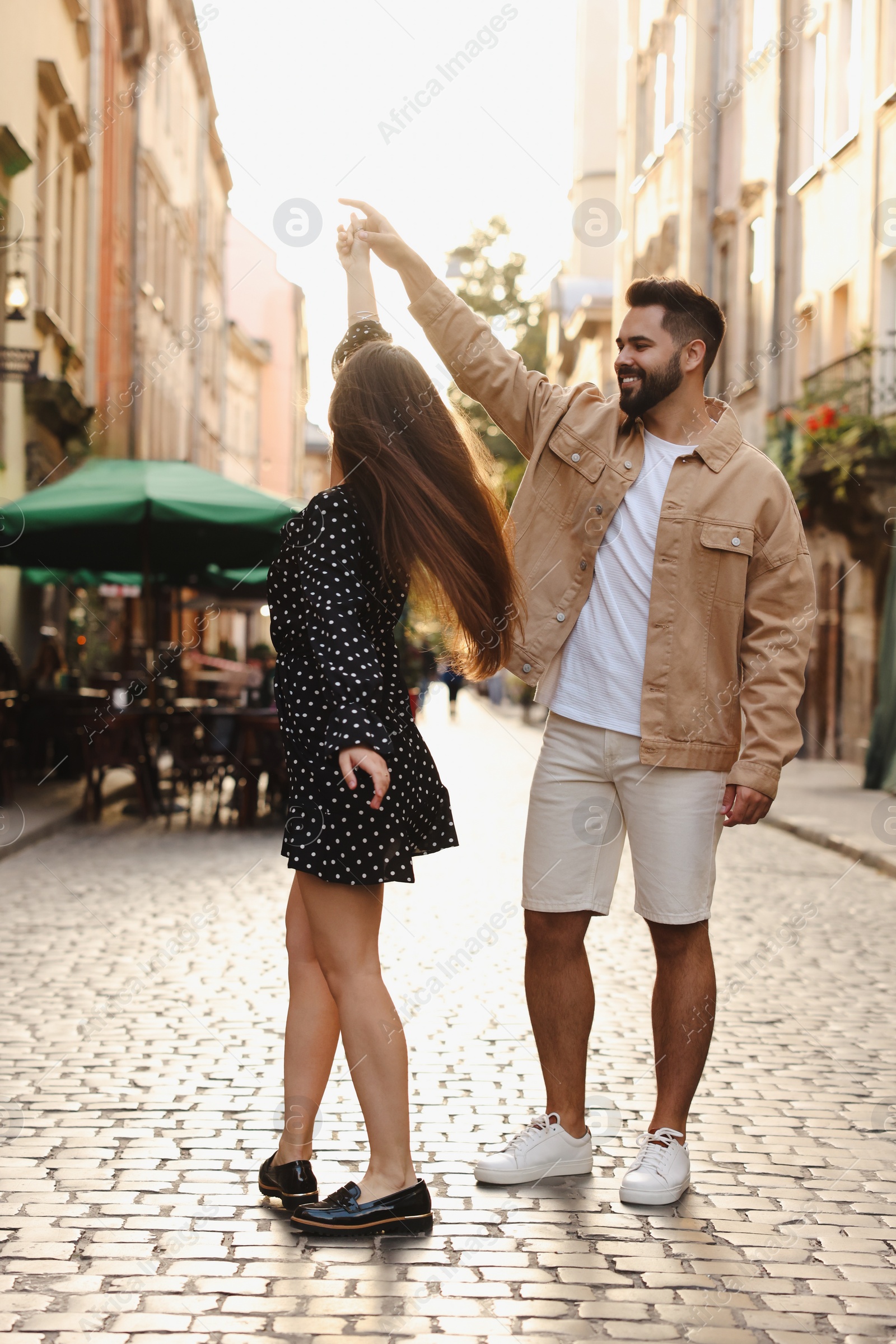 Photo of Lovely couple dancing together on city street