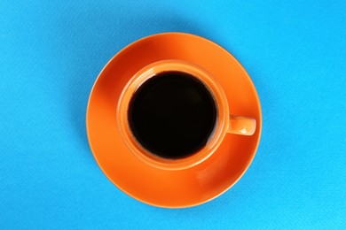 Photo of Coffee in cup on light blue background, top view
