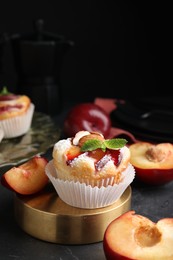 Photo of Delicious cupcakes with plums on black table, closeup