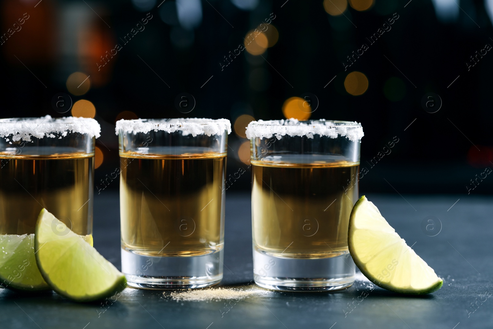 Photo of Mexican Tequila shots, lime slices and salt on bar counter