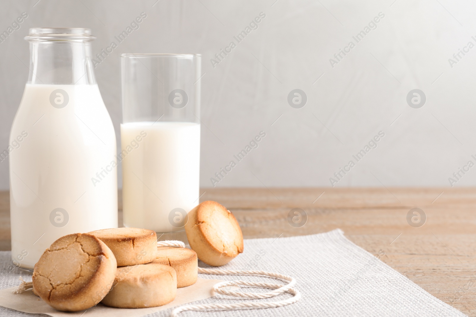 Photo of Tasty homemade cookies and milk on wooden table. Space for text