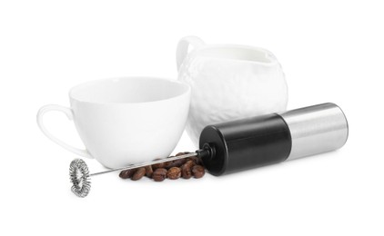 Photo of Mini mixer (milk frother), cup, coffee beans and pitcher isolated on white