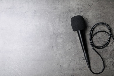 Modern microphone on grey background, top view with space for text