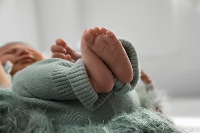 Photo of Cute newborn baby sleeping on fuzzy blanket, focus on legs