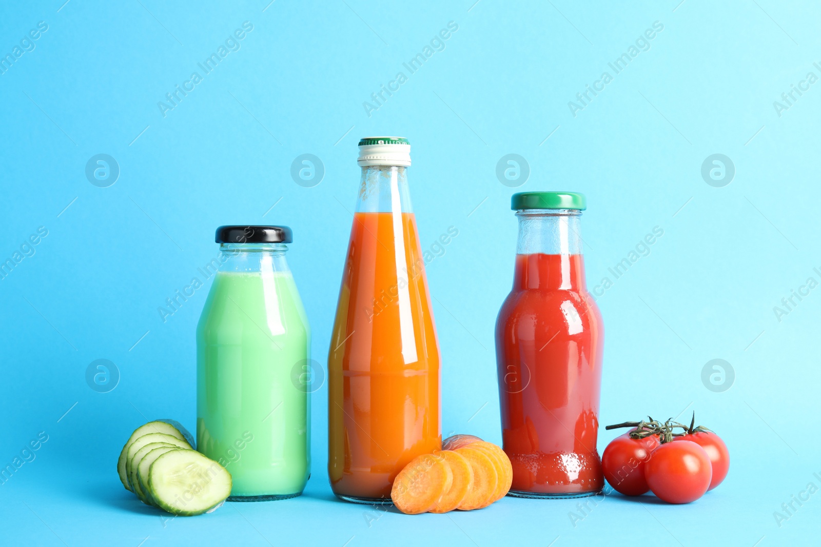 Photo of Bottles with different juices and fresh vegetables on color background