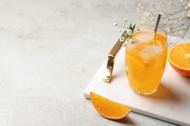 Delicious orange soda water on light table. Space for text