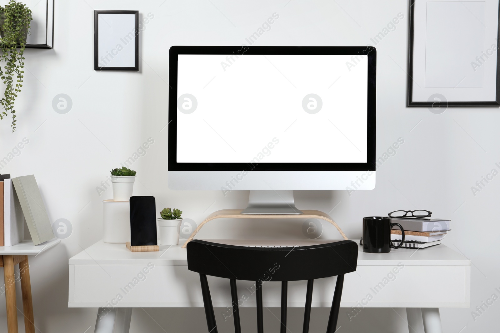 Photo of Cozy workspace with computer, smartphone and stationery on wooden desk at home