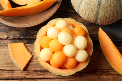 Different melon balls on wooden table, flat lay