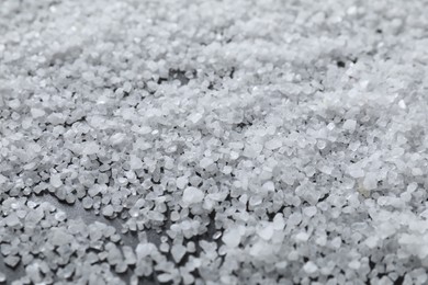 White natural salt as background, closeup view