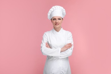 Photo of Happy woman chef in uniform on pink background