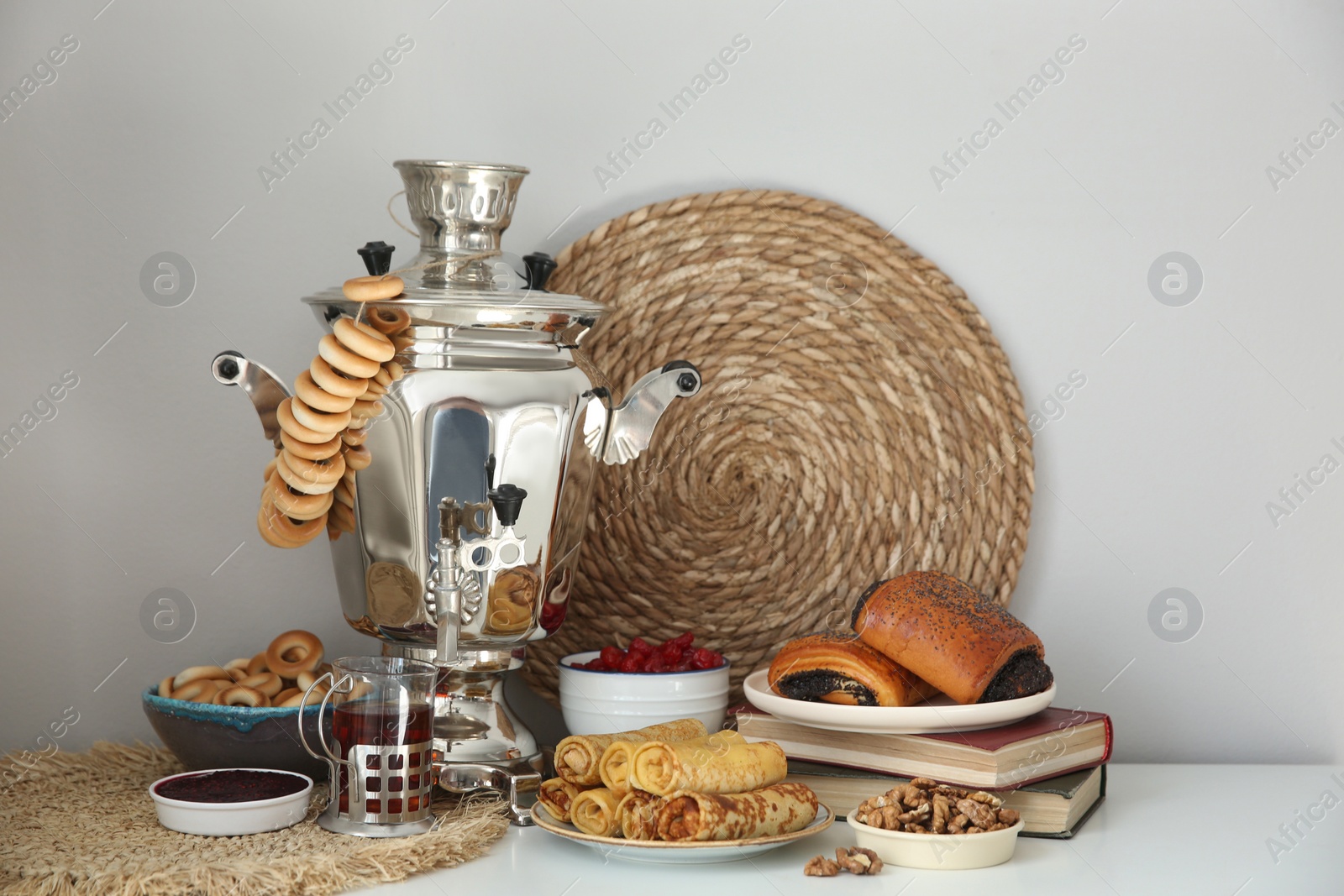 Photo of Traditional Russian samovar with treats on white table