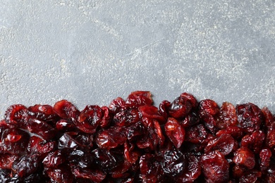 Photo of Tasty cranberries on grey background, top view with space for text. Dried fruit as healthy snack