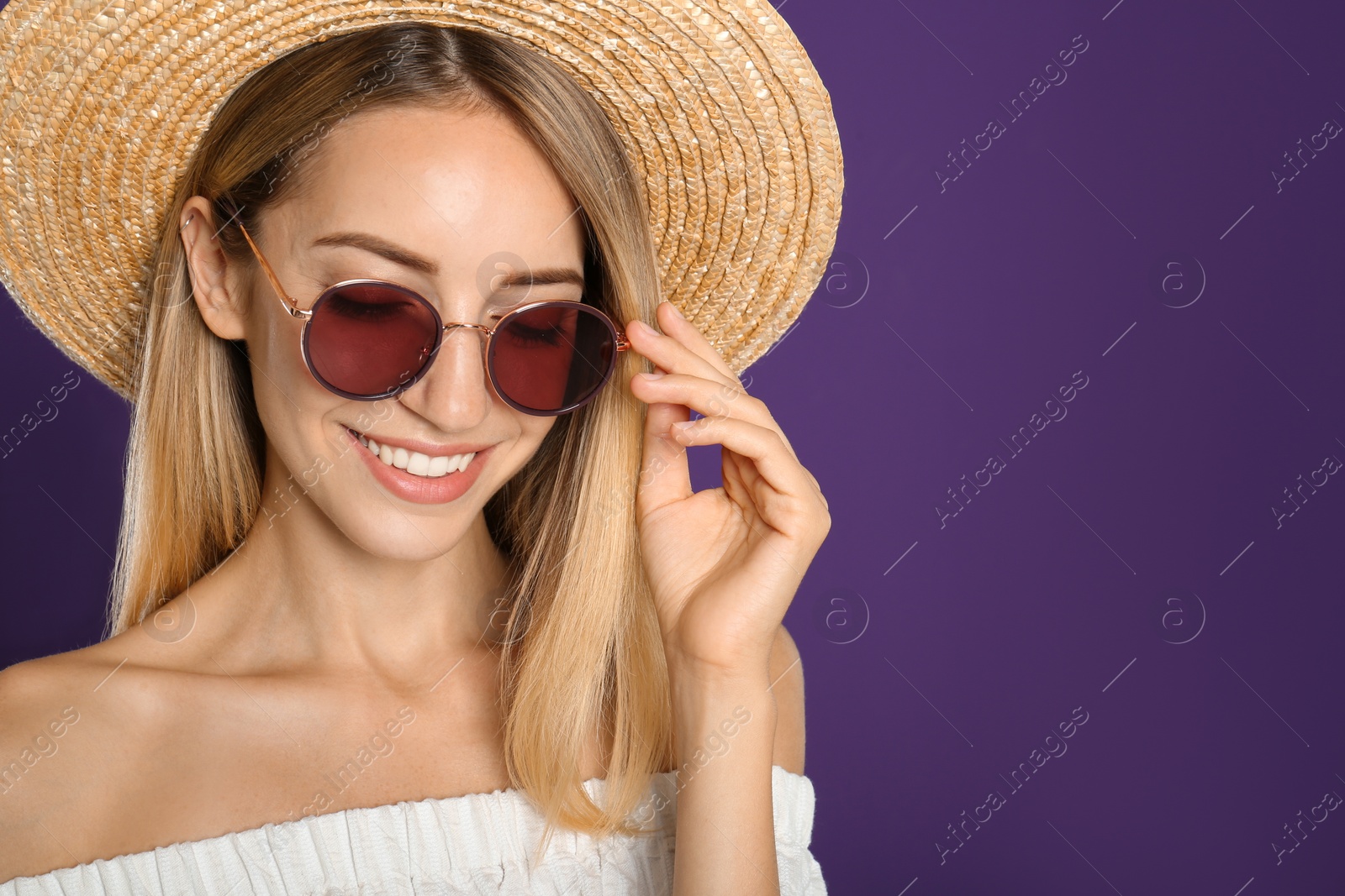 Photo of Beautiful woman in stylish sunglasses on purple background. Space for text