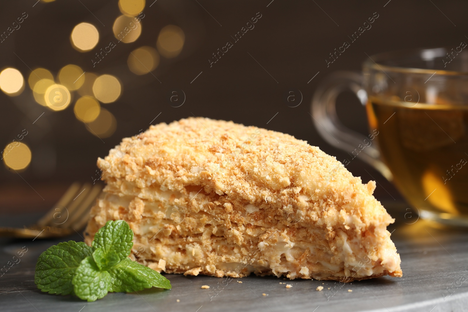 Photo of Piece of delicious Napoleon cake served on table, closeup