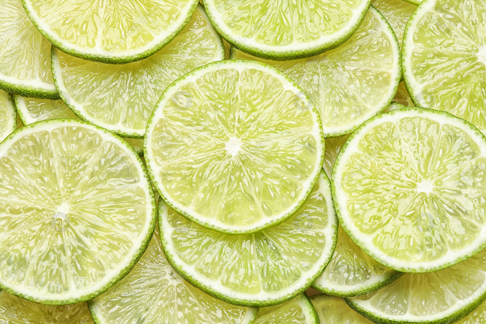 Photo of Many fresh juicy lime slices as background, top view