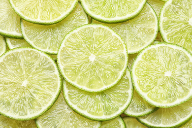 Many fresh juicy lime slices as background, top view