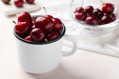 Photo of Fresh ripe cherries with water drops on white wooden table, closeup