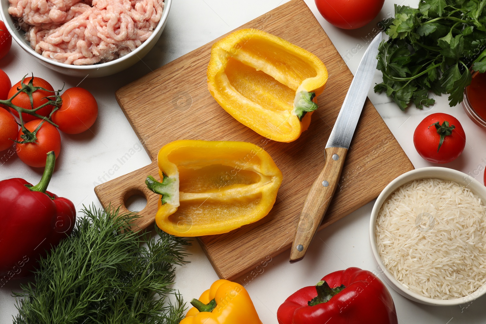 Photo of Raw stuffed peppers with ground meat and ingredients on white marble table, flat lay