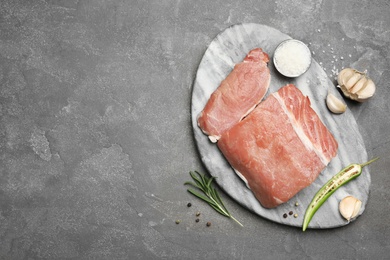 Flat lay composition with fresh raw cut meat on grey table. Space for text