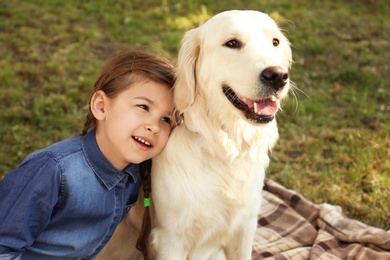 Photo of Cute little child with his pet in green park