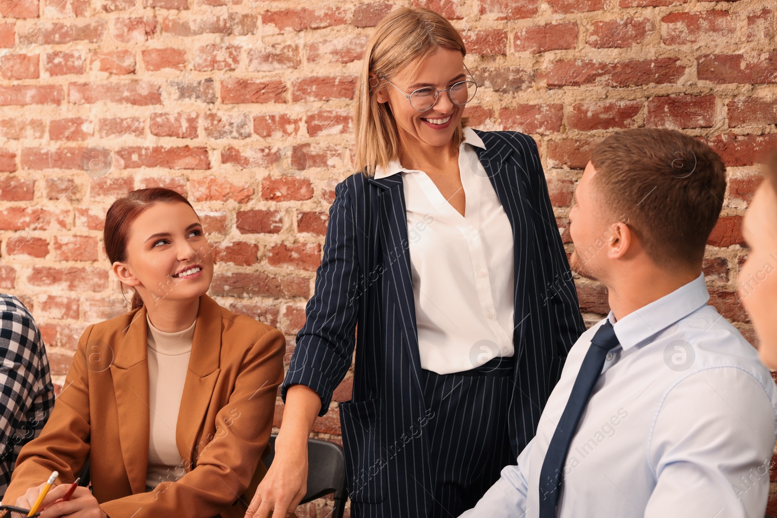 Photo of Businesswoman having meeting with her employees in office. Lady boss