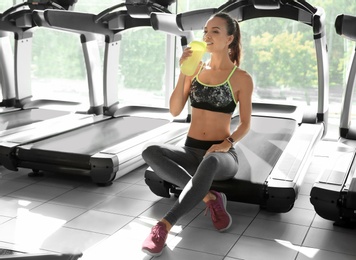 Photo of Portrait of athletic woman with protein shake in gym