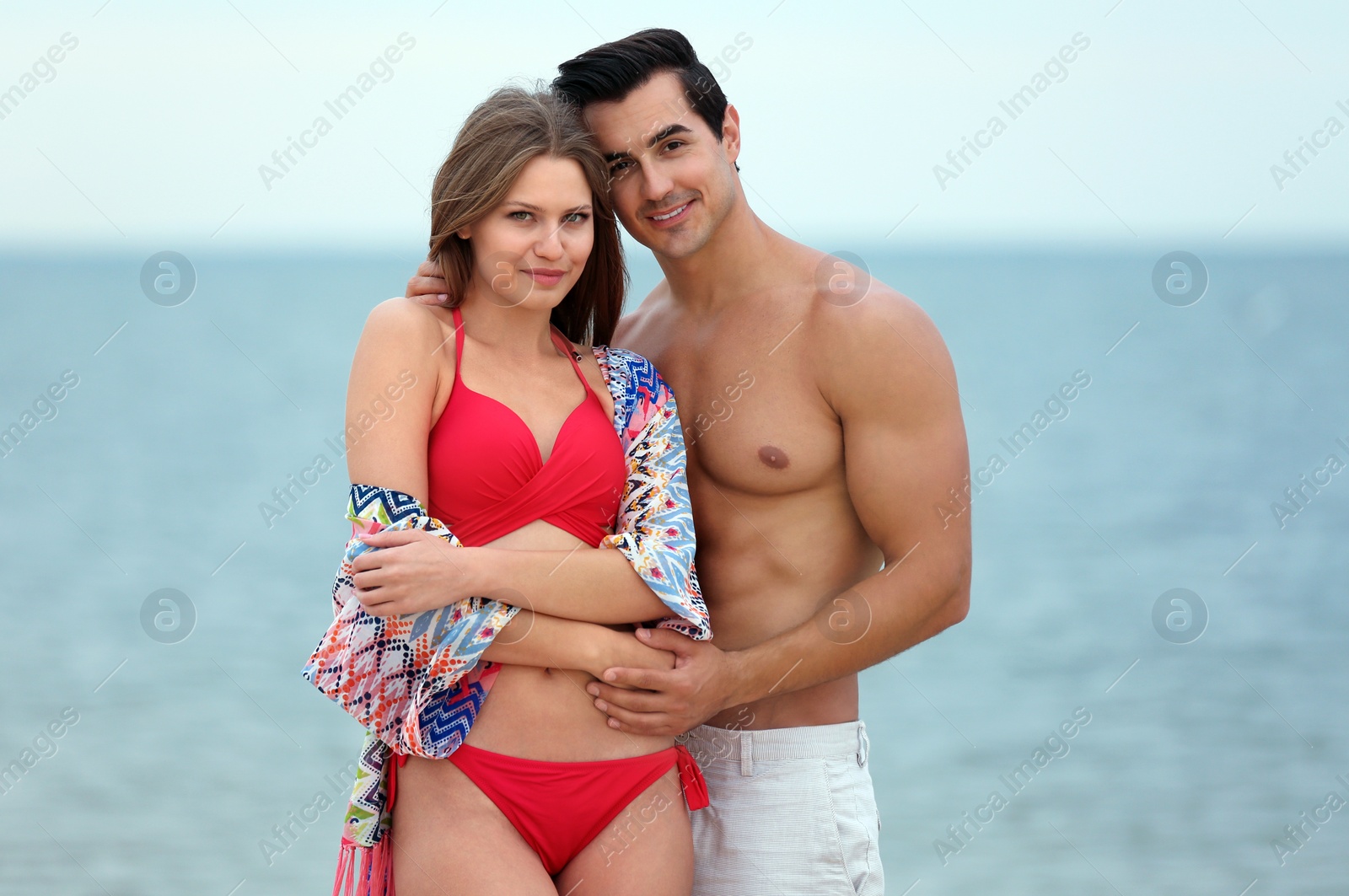 Photo of Happy young couple spending time together on sea beach