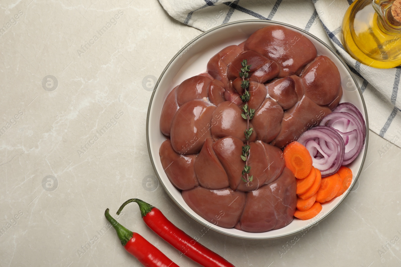Photo of Fresh raw kidney meat and vegetables on light grey table, flat lay