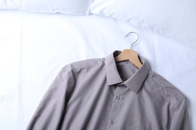 Photo of Stylish shirt on bed, top view. Dry-cleaning service