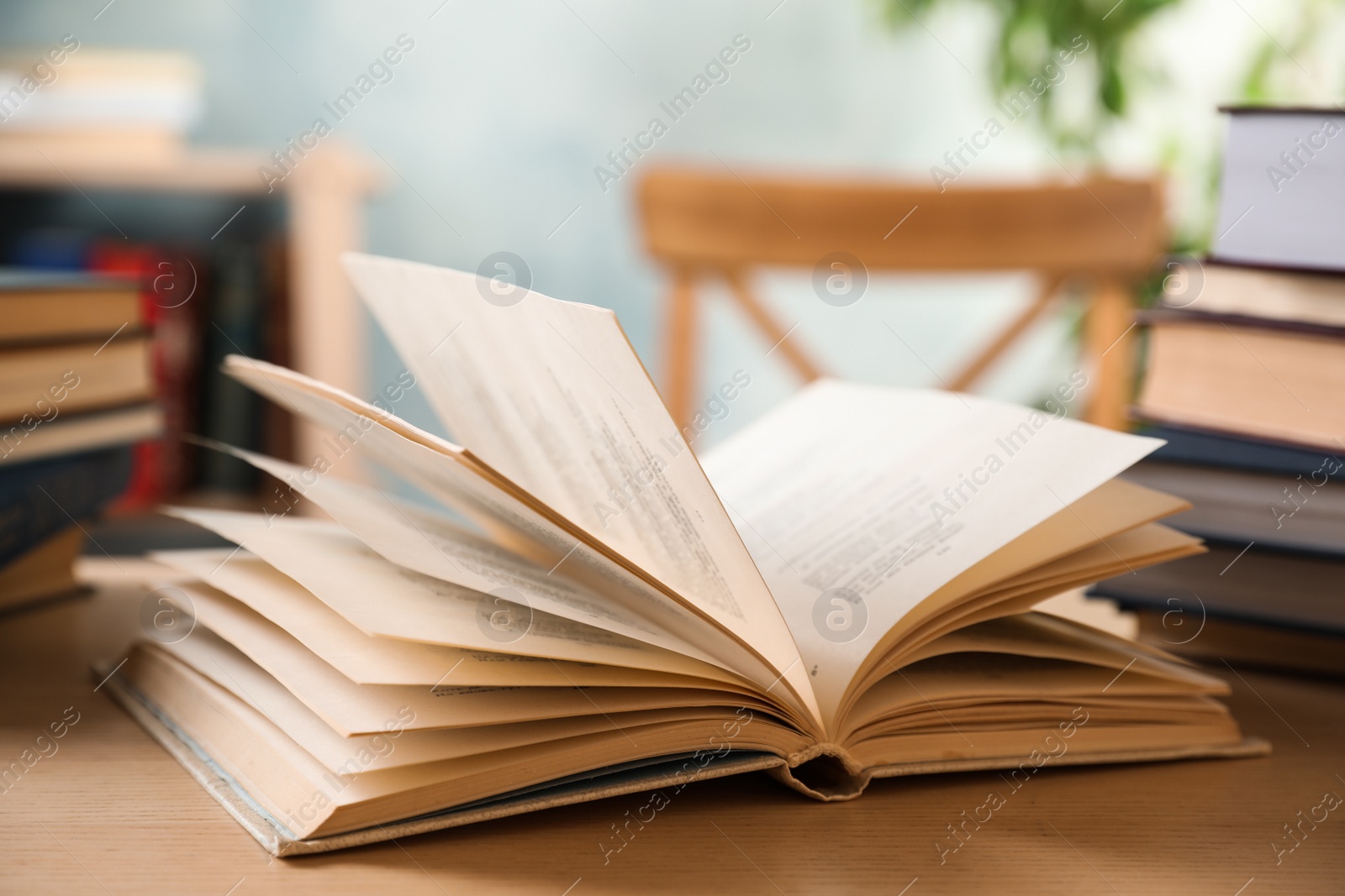 Photo of Open hardcover book on wooden table indoors