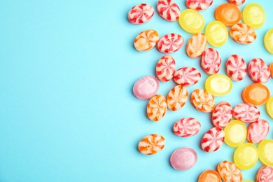 Photo of Flat lay composition with delicious colorful candies and space for text on color background