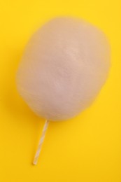 Photo of One sweet cotton candy on yellow background, top view