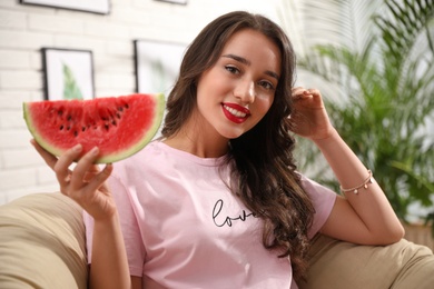 Photo of Beautiful young woman with watermelon at home