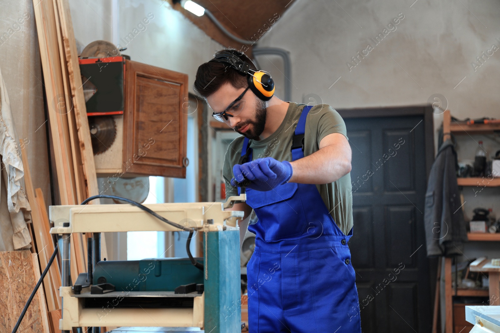 Photo of Professional carpenter working with grinding machine in shop