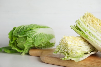 Photo of Delicious cut Chinese cabbage on white wooden table, closeup. Space for text