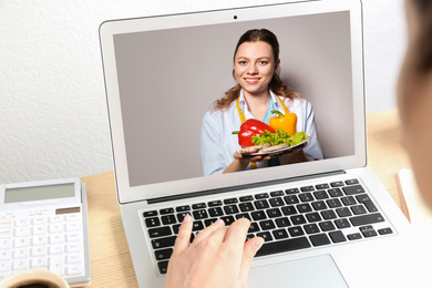Image of Woman using laptop for online consultation with nutritionist via video chat, closeup