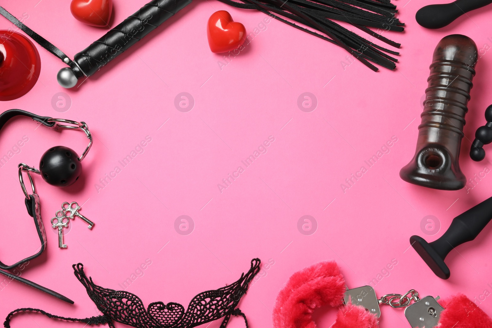 Photo of Frame of different sex toys on pink background, flat lay. Space for text