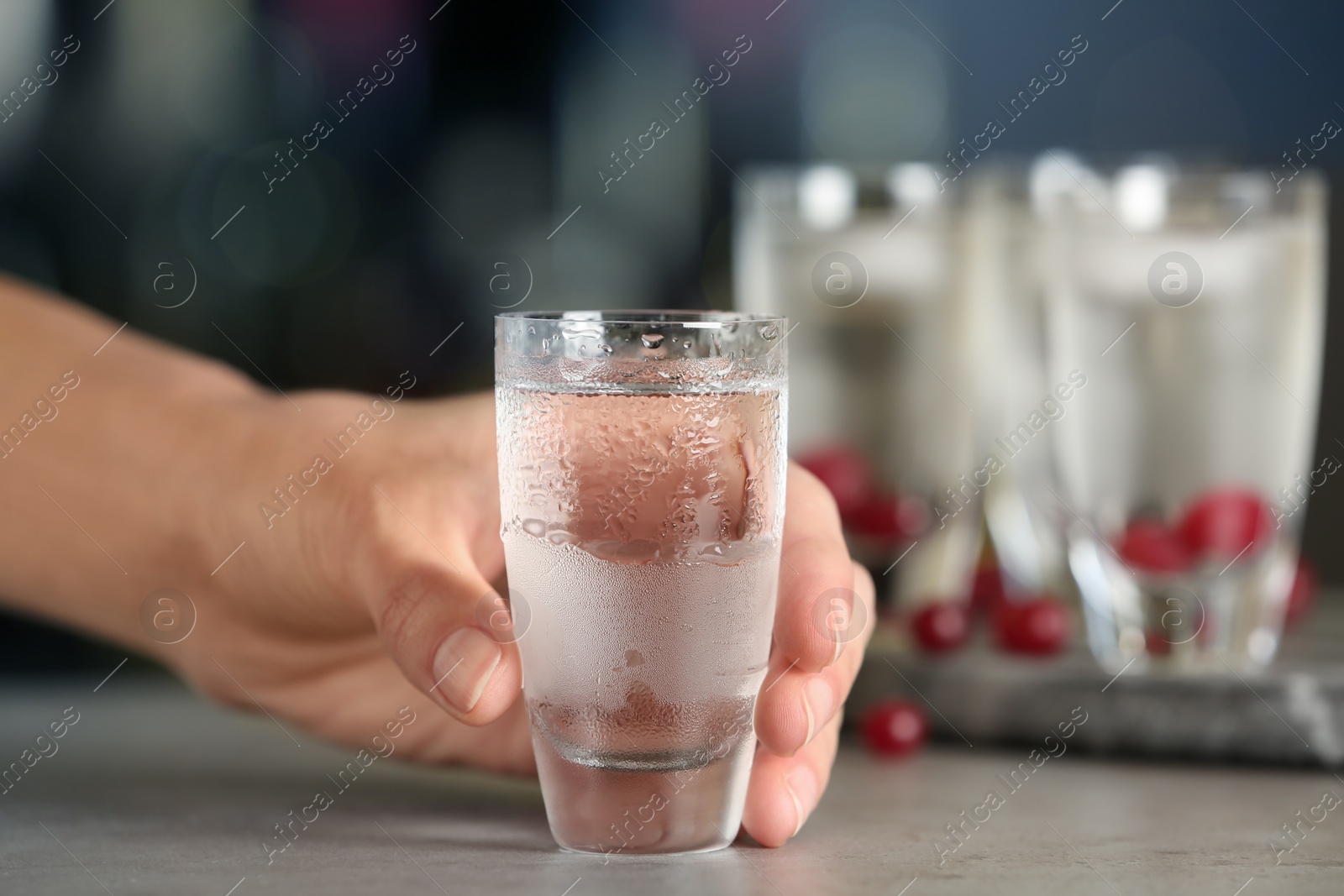 Photo of Woman with shot of vodka at table in bar, closeup