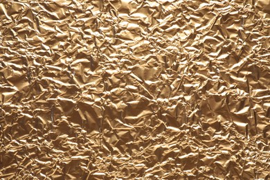 Crumpled gold foil as background, top view