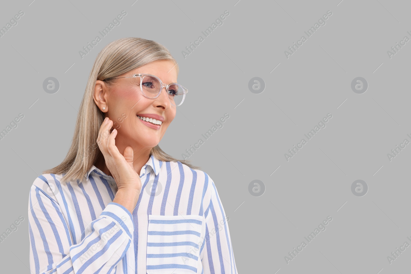 Photo of Portrait of beautiful middle aged woman in eyeglasses on light grey background, space for text