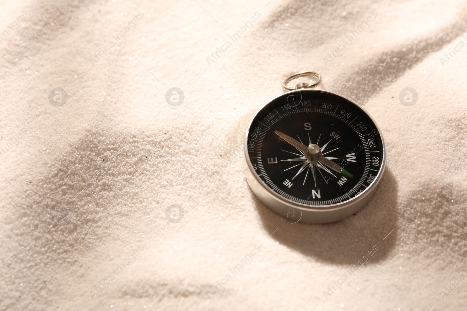 Photo of Compass on sand, space for text. Navigation equipment