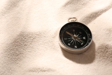 Photo of Compass on sand, space for text. Navigation equipment