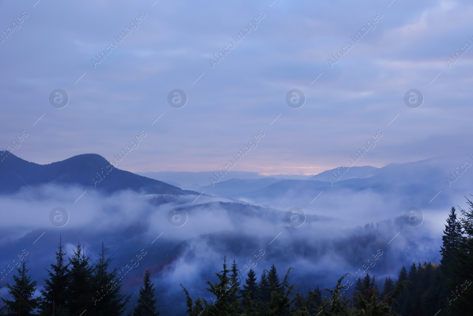 Photo of Beautiful view of mountains covered with fog during sunrise