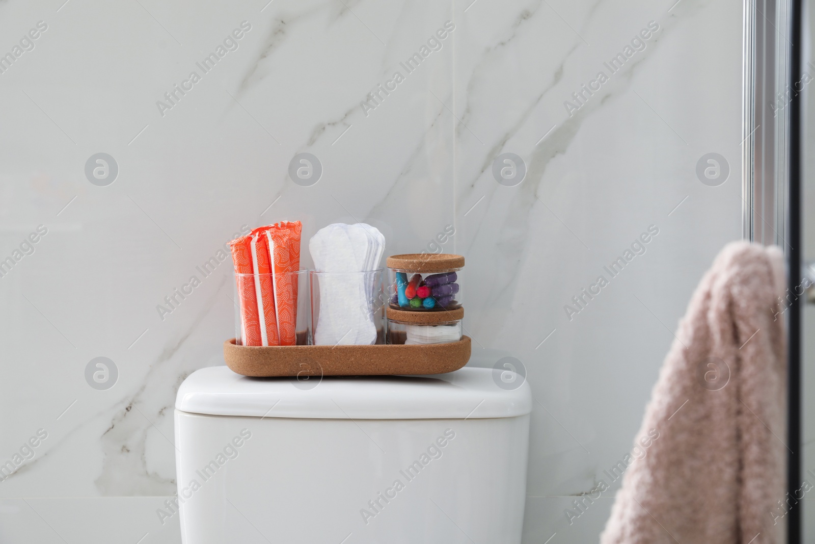 Photo of Organizer with different feminine hygiene products on toilet bowl in bathroom